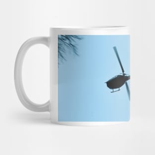 A Bell UH-1 Huey Iroquois flying low over trees Mug